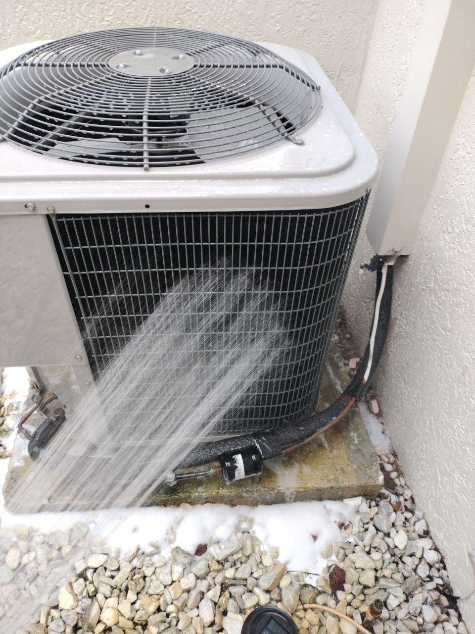 Outdoor A/C condenser being cleaned with water
