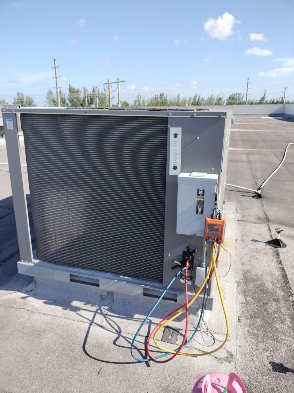 Rooftop A/C unit connected to diagnostic service gauges