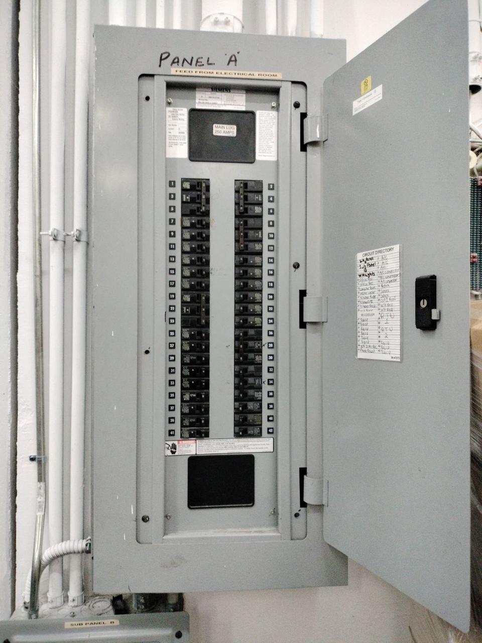 Open electrical breaker panel with labeled circuits